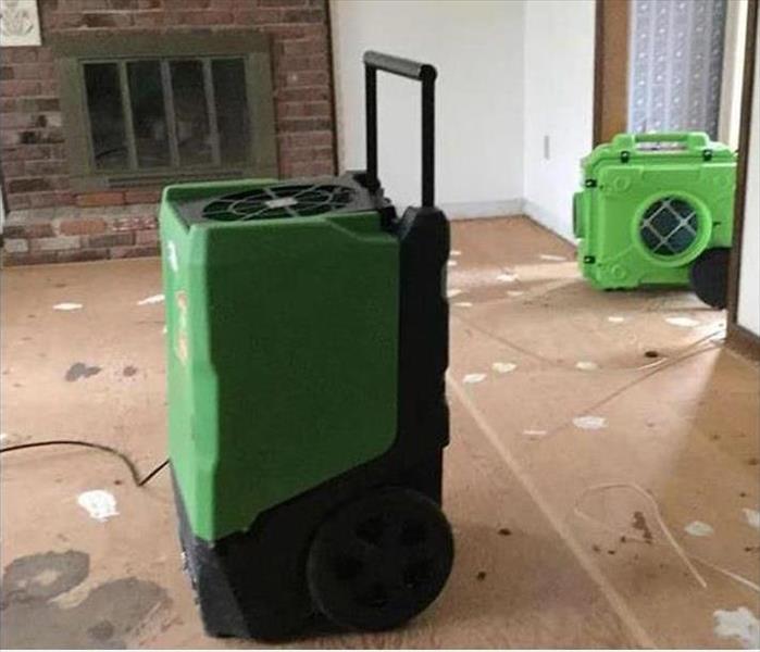 drying equipment on plywood floor, fireplace in back area